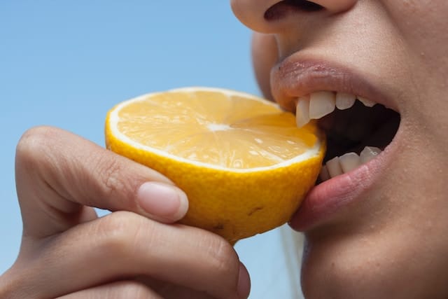 mulher mordendo limão