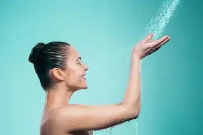 mulher no chuveiro preparando a higiene pessoal
