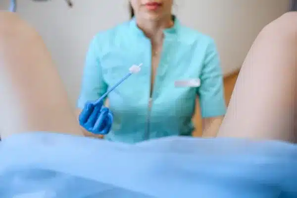 ginecologista fazendo exame de coleta de fluido vaginal