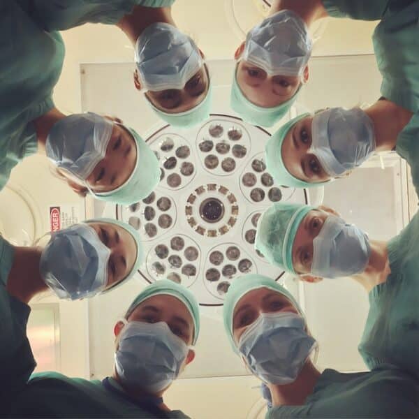 médicos em círculo olhando para paciente na maca