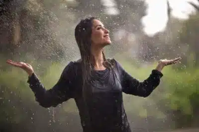 mulher na chuva, representando a saúde plena que previne infecções da candidíase
