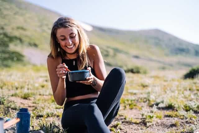 mulher fazendo dieta antifúngia e comendo com sorriso no rosto