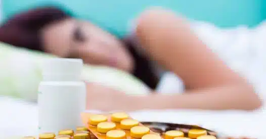 mulher doente de cama diante de medicamentos