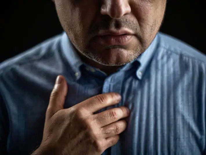 imagem de um homem com a mão no esôfago sentindo os sinais da esofagite por candida