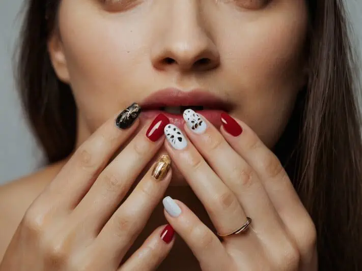 imagem de uma mulher assustada com a candidíase nas unhas e com cores de esmalte diferentes nas unhas.